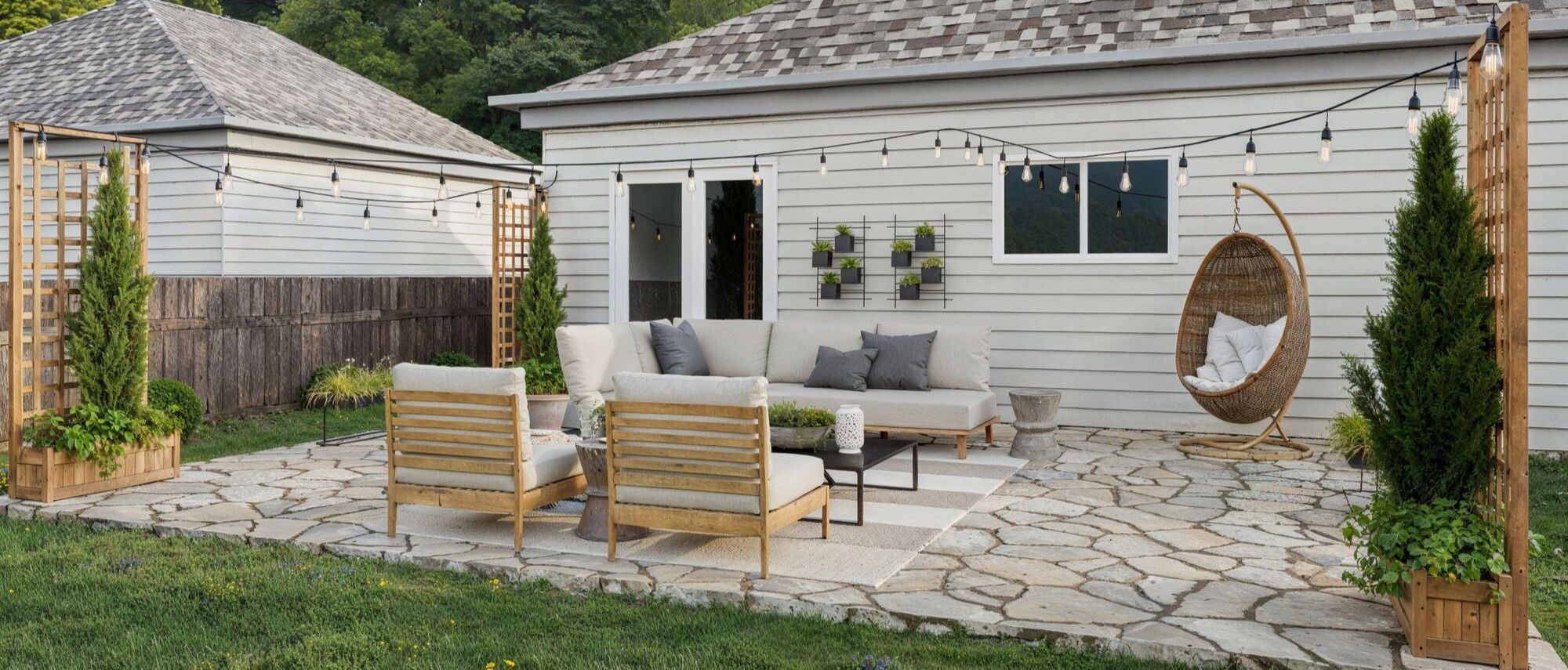 Flagstone Patio Design with Strung Lights by interior designers in Round Rock, Texas