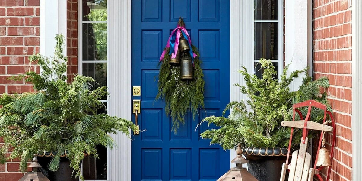 Evergreen fronds and bells winter door decoration