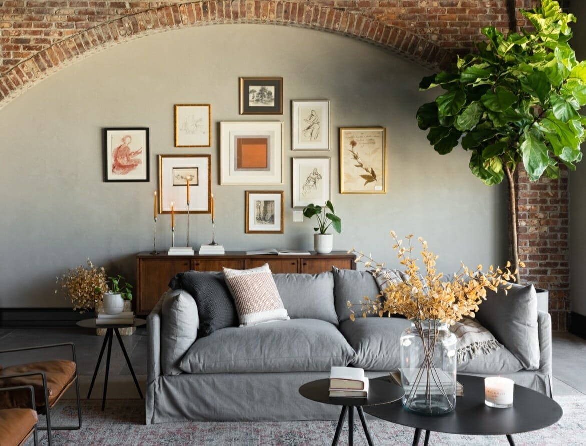 Living room with grey sofa and brick wall - haute bohemian